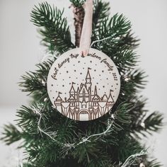 a wooden ornament hanging from a christmas tree with a disney castle on it