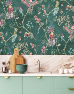 a kitchen with green wallpaper and colorful birds on it