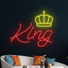 a neon sign that says king with a crown on it's head in front of a couch