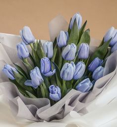 a bouquet of blue tulips sitting on top of a white cloth