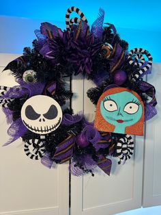 a wreath decorated with purple and black mesh, featuring jack skellingy faces on the front door