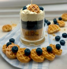 some waffles and blueberries on a plate with a cupcake in the middle