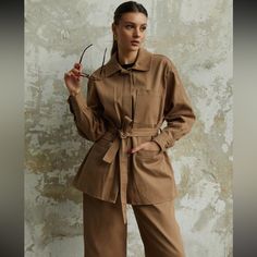 Gabardine Belted Tan Shirt Jacket Lapel Collar Outerwear With Pockets For Daywear, Utility Long Sleeve Outerwear With Buckled Cuffs, Belted Long Sleeve Utility Jacket, Brown Spring Outerwear With Belted Cuffs, Fall Outerwear With Belted Cuffs For Daywear, Belted Long Sleeve Outerwear For Daywear, Khaki Belted Long Sleeve Outerwear, Spring Brown Utility Jacket For Workwear, Belted Utility Jacket