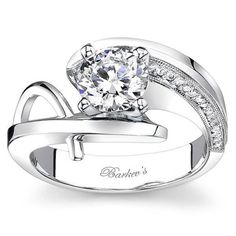 a white gold engagement ring set with an oval cut diamond and channeled accents on the band