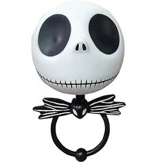 a ring with a skeleton face and black eyes on it's head is hanging from a hook