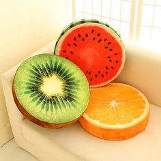 three slices of watermelon, orange and kiwi fruit on a white couch