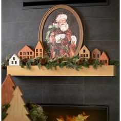 a fireplace mantel decorated with christmas decorations and santa clause on it's mantle