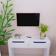 a white table with two drawers and a plant on top