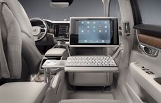 the interior of a car with a laptop and keyboard on it's trays