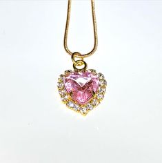 An elegant pink crystal heart on a delicate gold chain. Pink Crystal Heart Pendant Jewelry, Pink Crystal Heart Pendant Necklace, Pink Heart-shaped Clavicle Chain Jewelry, Pink Heart-shaped Jewelry With Clavicle Chain, Rose Gold Heart-shaped Chain Necklace, Pink Heart Cut Necklace For Party, Pink Heart Cut Jewelry For Party, Pink Heart Pendant Clavicle Necklace, Pink Crystal Necklace With Heart Charm