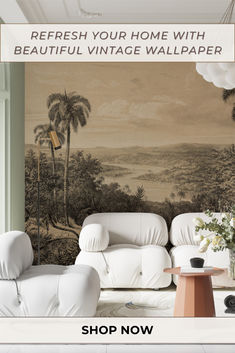 a living room with white furniture and palm trees on the wall, in front of a large painting