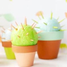 four small cactus plants in pots on a table