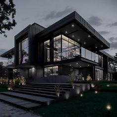 a large modern house lit up at night with lights on the windows and steps leading to it