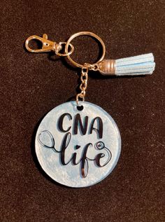 a keychain with the words cna life on it and a tassel