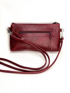 stylish hands free cross body bag with long strap and  wristlet strap *  can be used as evening clutch or cross body *  deep burgundy red rich leather *  zipper pocket on outside rear and 1 slip pocket inside *  fully lined with complimentary fabric *  silver hardware and ykk zipper closure *  measures 6 inches by 9 inches with gusset bottom *  53 inch strap          can be shortened Burgundy Crossbody Bag With Cell Phone Pocket, Burgundy Crossbody Shoulder Bag With Removable Pouch, Burgundy Crossbody Shoulder Bag With Cell Phone Pocket, Burgundy Leather Shoulder Bag With Mobile Phone Pouch, Burgundy Leather Shoulder Bag With Mobile Phone Holder, Leather Shoulder Bag With Mobile Phone Bag In Burgundy, Burgundy Leather Shoulder Bag With Phone Holder, Burgundy Crossbody Bag With Zipper Closure, Burgundy Evening Bag With Zipper Closure