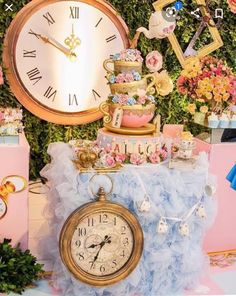 a table topped with a clock next to a wall covered in flowers and other decorations