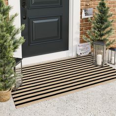 the front door is decorated with christmas trees and lanterns for holiday decor, as well as two small evergreens