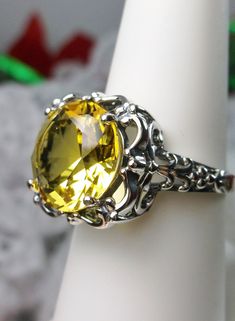 Simulated Yellow Citrine Ring Description Speechless Design#103 MADE TO ORDER Inspired by Victorian era filigree designs, I now offer this stunning Antique inspired ring in sterling silver. This fabulous ring is set with a 6ct flawless Man-made/Simulated citrine gemstone. The round full cut high-quality blue gemstone is 12mm (just shy of 1/2th of an inch) in diameter. The inside of the band is marked 925 for sterling. Notice the beautiful intricate bow and floral-like design of the silver filigr Classic Citrine Ring Jewelry, Formal Round Citrine Crystal Ring, Formal Citrine Crystal Round Ring, Formal Citrine Crystal Ring, Classic Citrine Jewelry With Diamond Cut, Formal Filigree Topaz Ring, Victorian Style Round Topaz Jewelry, Topaz Filigree Round Ring, Ornate Round Topaz Gemstone Ring