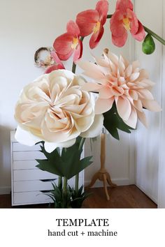 a vase filled with flowers sitting on top of a wooden floor next to a white wall