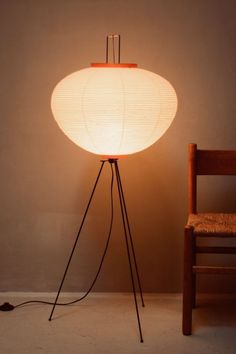 a floor lamp sitting next to a wooden chair