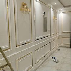 an empty room with white walls and gold trimmings on the doors, flooring and chandeliers