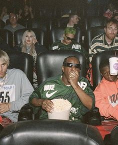 people sitting in the audience watching a movie at an event with their faces covered by paper cups