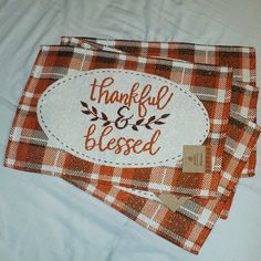 two orange and white plaid napkins with the words, grateful and blessed on them