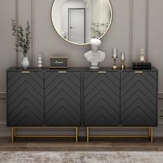 a black and gold sideboard with a round mirror on the wall next to it