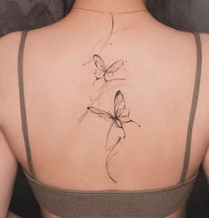 the back of a woman's shoulder with a butterfly tattoo on it