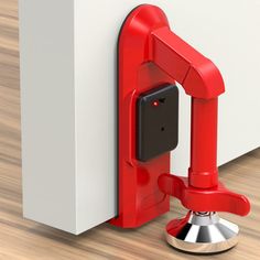 a red phone holder attached to the side of a white wall next to a wooden floor