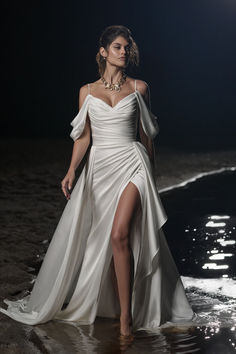 a woman is walking in the water wearing a white dress and high heeled sandals