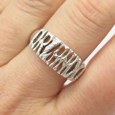 a close up of a person's hand wearing a silver ring with the word love on it