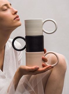 a woman is holding a coffee mug with her face in the air