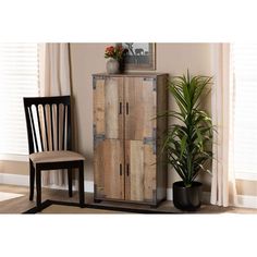 a wooden cabinet sitting next to a chair and potted plant in a living room