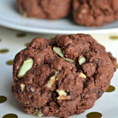 two white plates with cookies and one chocolate cookie on it, sitting next to each other