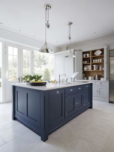 a kitchen with blue cabinets and an island in front of the countertop is shown