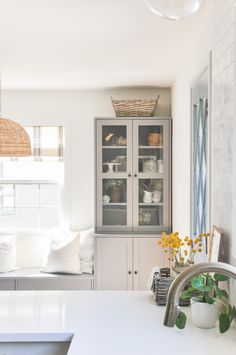 a kitchen with white counter tops and cabinets