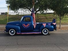 a blue truck with an american flag on the back