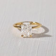 a yellow gold engagement ring with a cushion cut diamond