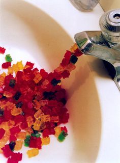 a bunch of gummy bears sitting on top of a bathroom sink next to a faucet