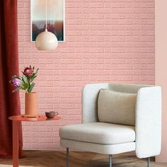 a white chair sitting next to a pink brick wall