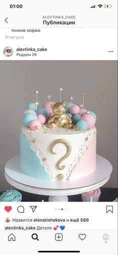 the cake is decorated with pink, blue and gold icing on it's side