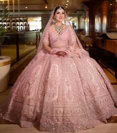 a woman in a pink bridal gown posing for the camera