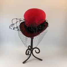 Elevate your fashion game with this exquisite Makshy red heart-shaped cocktail hat fascinator. This accessory is more than just a hat - it's a work of art, expertly crafted by hand in Great Britain. Designed to turn heads, it's the perfect way to add a touch of sophistication and playfulness to any outfit. HAT FEATURES ◦ Unique heart shape achieved through the use of the milliner's own hand-crafted hat block. ◦ Crafted with intricate details and reinforced with millinery wiring to maintain the hat brim's shape over time. ◦ Individually hand-sewn for exceptional attention to detail. ◦ Lined with luxurious silk for added comfort and style. ◦ Custom-made to order for a truly bespoke experience. The fascinator is crafted from high-quality wool felt, renowned for its durability, warmth, and sof Elegant Red Cloche Hat For Winter, Elegant Red Felt Hat For Formal Occasions, Red Wool Felt Hat With Curved Brim, Red Fitted Hat For Gift, Elegant Fitted Red Felt Hat, Red Fitted Hat As Gift, Red Fitted Hats As Gifts, Handmade Red Party Hat, Formal Winter Red Felt Hat