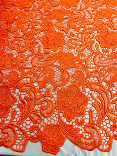 an orange lace table cloth with flowers on it