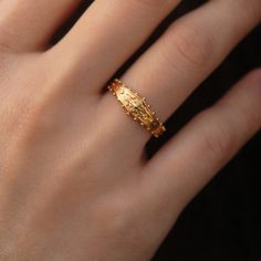 a woman's hand with a gold ring on it