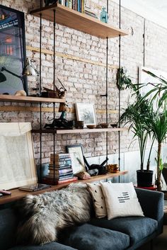 a living room filled with lots of furniture and bookshelves next to a brick wall