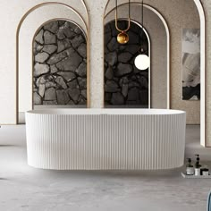 a large white bath tub sitting in a bathroom next to two arched windows and a stone wall