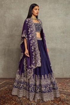 Purple asymmetric cutwork cape with floral embroidered motifs. Paired with floral embroidered scallop hem lehenga and embroidered bustier.
Component: 3
Pattern: Embroidered
Type Of Work: Floral
Neckline: Open
Sleeve Type: Flared Sleeves
Fabric: Raw Silk
Color: Purple
Other Details: 
Scallop hem lehenga
Floral motifs
Asymmetric cape
Occasion: Bride, Sangeet - Aza Fashions Cape Lehenga, Purple Lehenga, Sangeet Outfit, Jayanti Reddy, Raw Silk Lehenga, Mehendi Outfits, Wedding Lehenga Designs, Lehenga Designs Simple, Gaun Fashion