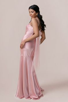 a woman in a pink dress is posing for the camera